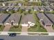 Aerial view of a neighborhood featuring a well-maintained home with lush landscaping and a brick paver driveway at 605 Cantabria Dr, Davenport, FL 33837