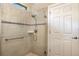 The bathroom has a glass enclosed shower with horizontal tile accents and a grab bar at 605 Cantabria Dr, Davenport, FL 33837