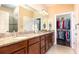 The bathroom features double sinks, granite countertop, and entrance to the walk-in closet at 605 Cantabria Dr, Davenport, FL 33837