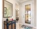 Inviting foyer with decorative glass door, mirrored wall, and stylish console table at 605 Cantabria Dr, Davenport, FL 33837