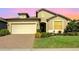 Charming single-story home with a well-manicured lawn and a two-car garage with a brick paver driveway at 605 Cantabria Dr, Davenport, FL 33837