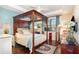This spacious main bedroom features a four poster bed and warm wood floors at 605 Cantabria Dr, Davenport, FL 33837