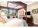 The main bedroom has a decorative wood four poster bed and lots of natural light at 605 Cantabria Dr, Davenport, FL 33837