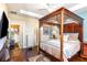 This main bedroom features a decorative wood four poster bed, ensuite, and a laundry room at 605 Cantabria Dr, Davenport, FL 33837