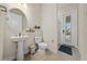 Clean bathroom with pedestal sink, toilet, and access to backyard at 8024 Leaf Grove Cir, Orlando, FL 32836