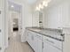Bathroom with granite countertop, white cabinets, and a view down the hall at 8024 Leaf Grove Cir, Orlando, FL 32836