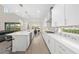 Open concept kitchen boasts white cabinets, an island, and hardwood floors at 8024 Leaf Grove Cir, Orlando, FL 32836
