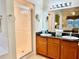 Bathroom with double sinks, shower, and view into bedroom at 8100 Poinciana Blvd # 2405, Orlando, FL 32821