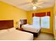 Bedroom with two twin beds and ceiling fan at 8100 Poinciana Blvd # 2405, Orlando, FL 32821