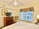 King bedroom with a dresser, chair and window views at 8100 Poinciana Blvd # 2405, Orlando, FL 32821