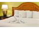 King-size bed with nightstands and a decorative towel swan at 8100 Poinciana Blvd # 2405, Orlando, FL 32821