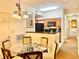 Cozy dining area featuring a glass table, woven chairs, and a view of the kitchen at 8100 Poinciana Blvd # 2405, Orlando, FL 32821