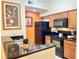 Well-equipped kitchen featuring black appliances, granite counters, and warm-toned wood cabinets at 8100 Poinciana Blvd # 2405, Orlando, FL 32821