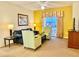 Comfortable living room with yellow walls, balcony access, and TV at 8100 Poinciana Blvd # 2405, Orlando, FL 32821