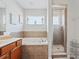 Bathroom with soaking tub, walk-in shower, and wood cabinets at 901 Marcello Blvd, Kissimmee, FL 34746