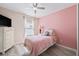 Charming bedroom with pink accent wall and ceiling fan at 901 Marcello Blvd, Kissimmee, FL 34746