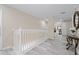 Upstairs hallway with white railings, grey flooring, and decorative console table at 901 Marcello Blvd, Kissimmee, FL 34746