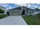 Green house with two-car garage and landscaped lawn at 1015 Sabine Pl, Kissimmee, FL 34759