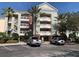 Beautiful condo building featuring multiple balconies, lush landscaping, and ample parking spaces at 1108 Sunset View Cir # 204, Reunion, FL 34747
