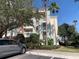A low angle side view shows the exterior of the building with balconies and tropical landscaping at 1108 Sunset View Cir # 204, Reunion, FL 34747