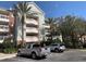 A low angle view shows the exterior of the building with large palm trees in front of the structure at 1108 Sunset View Cir # 204, Reunion, FL 34747