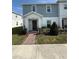 Charming two-story townhome featuring a well-maintained lawn and brick walkway leading to the front entrance at 1158 Sand Torch, Davenport, FL 33837