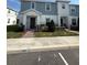 Charming two-story townhome with a beautifully landscaped front yard, brick walkway, and craftsman-style architectural details at 1158 Sand Torch, Davenport, FL 33837