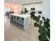 Modern kitchen with a large island, stainless steel appliances, and white cabinetry, open to dining area at 1158 Sand Torch, Davenport, FL 33837