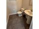 Small bathroom with pedestal sink, toilet, and dark-tiled floor at 122 Macaulays Cv, Haines City, FL 33844