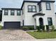 Two-story house with a gray and white exterior, a two-car garage, and landscaping at 122 Macaulays Cv, Haines City, FL 33844