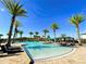 Gorgeous community pool featuring sparkling water, multiple palm trees, lounge chairs, and a covered gazebo at 122 Macaulays Cv, Haines City, FL 33844