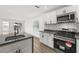 Modern kitchen with an island, stainless steel appliances, and white cabinets at 13404 Sw 60Th Court Rd, Ocala, FL 34473