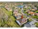 An aerial view of a single-story home in a suburban neighborhood near a lake at 203 Los Gatos Pl, Poinciana, FL 34759