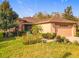 Charming single-story home with a well-manicured lawn and lush tropical landscaping at 203 Los Gatos Pl, Poinciana, FL 34759