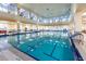 Indoor swimming pool with large windows and high ceilings at 203 Los Gatos Pl, Poinciana, FL 34759