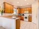 Well-equipped kitchen featuring wood cabinets, tile flooring, and a breakfast bar at 203 Los Gatos Pl, Poinciana, FL 34759