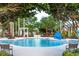 Community swimming pool with lounge chairs and umbrellas at 203 Los Gatos Pl, Poinciana, FL 34759