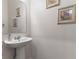 Small powder room with pedestal sink and framed artwork at 2455 Varenna Loop # 1, Kissimmee, FL 34741