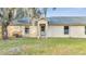 Exterior view of a light beige house with a gray roof and landscaping at 2650 Hilliard Ct, Kissimmee, FL 34744