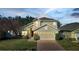 Two-story house with beige siding, a two-car garage, and a manicured lawn at 2751 Stanwood Dr, Kissimmee, FL 34743