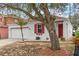 One-story home with red door and large tree at 319 Sand Ridge Dr, Davenport, FL 33896