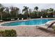 Community pool and patio area with lounge chairs, tables, and a black metal fence in a lush environment at 3459 Allegra Cir, St Cloud, FL 34772