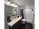 Well-lit bathroom featuring a single sink vanity, toilet, and a shower with white tiling at 4575 S Texas Ave # 207, Orlando, FL 32839