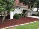 Inviting exterior with mulch bed, trimmed shrubs and trees framing the property and walking path at 4575 S Texas Ave # 207, Orlando, FL 32839