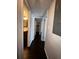 Hallway leading to the bathroom, bedroom, and closet, featuring dark wood floors at 4575 S Texas Ave # 207, Orlando, FL 32839