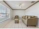 Living room with tiled floors, sofa, chair, ottoman, and large window at 46 W Marbrisa Way, Kissimmee, FL 34743