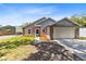 Gray house with stone accents, two-car garage, and American flag at 4755 Oakwood Dr, St Cloud, FL 34772