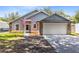 Gray house with stone accents, two-car garage, and American flag at 4755 Oakwood Dr, St Cloud, FL 34772