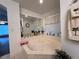 Corner bathtub with a large mirror and window at 5030 Haywood Ruffin Rd, St Cloud, FL 34771