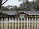 Brick home with a white picket fence and manicured landscaping at 5030 Haywood Ruffin Rd, St Cloud, FL 34771